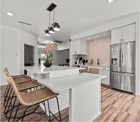 a kitchen with a large island and a stainless steel refrigerator